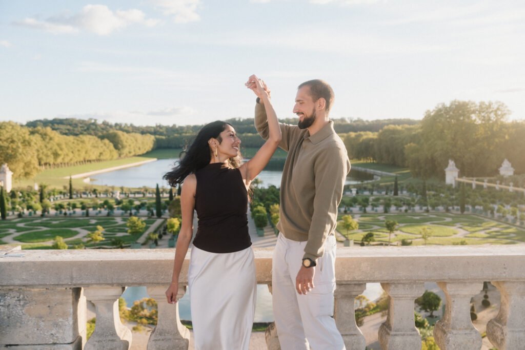 Couple dansant sur une terrasse dominant les jardins de Versailles
