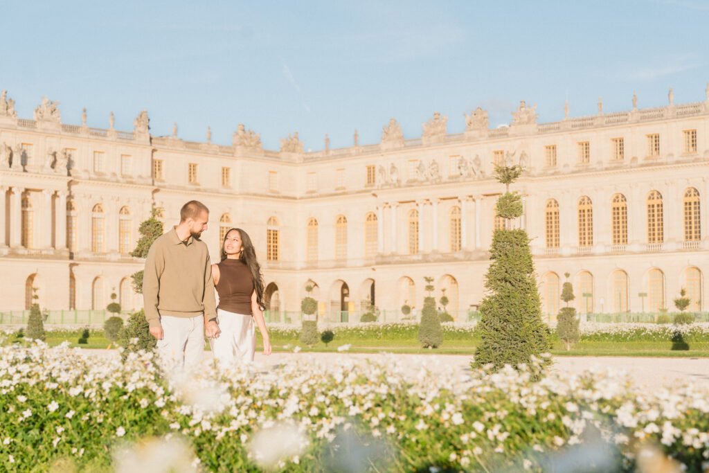 Couple marchant dans les jardins de Versailles, avec des fleurs au premier plan