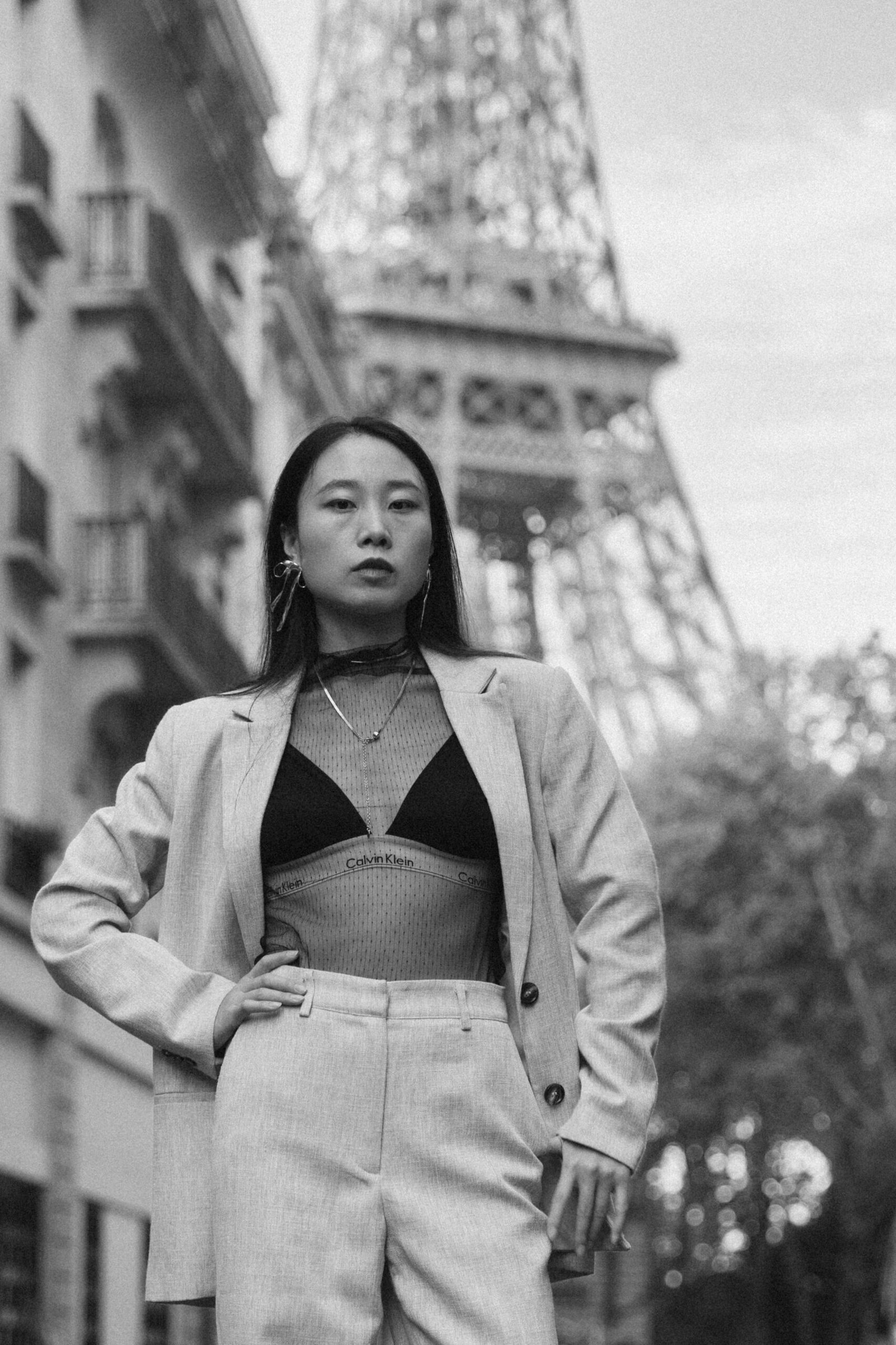 Portrait noir et blanc d'Eva, avec la tour Eiffel à l'arrière-plan.