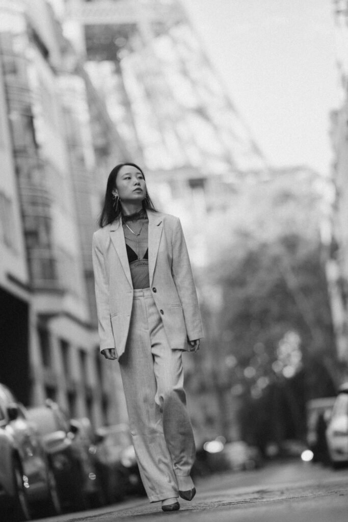 Portrait en pied et en noir et blanc d'Eva en mouvement, avec une perspective basse qui renforce l'atmosphère urbaine.